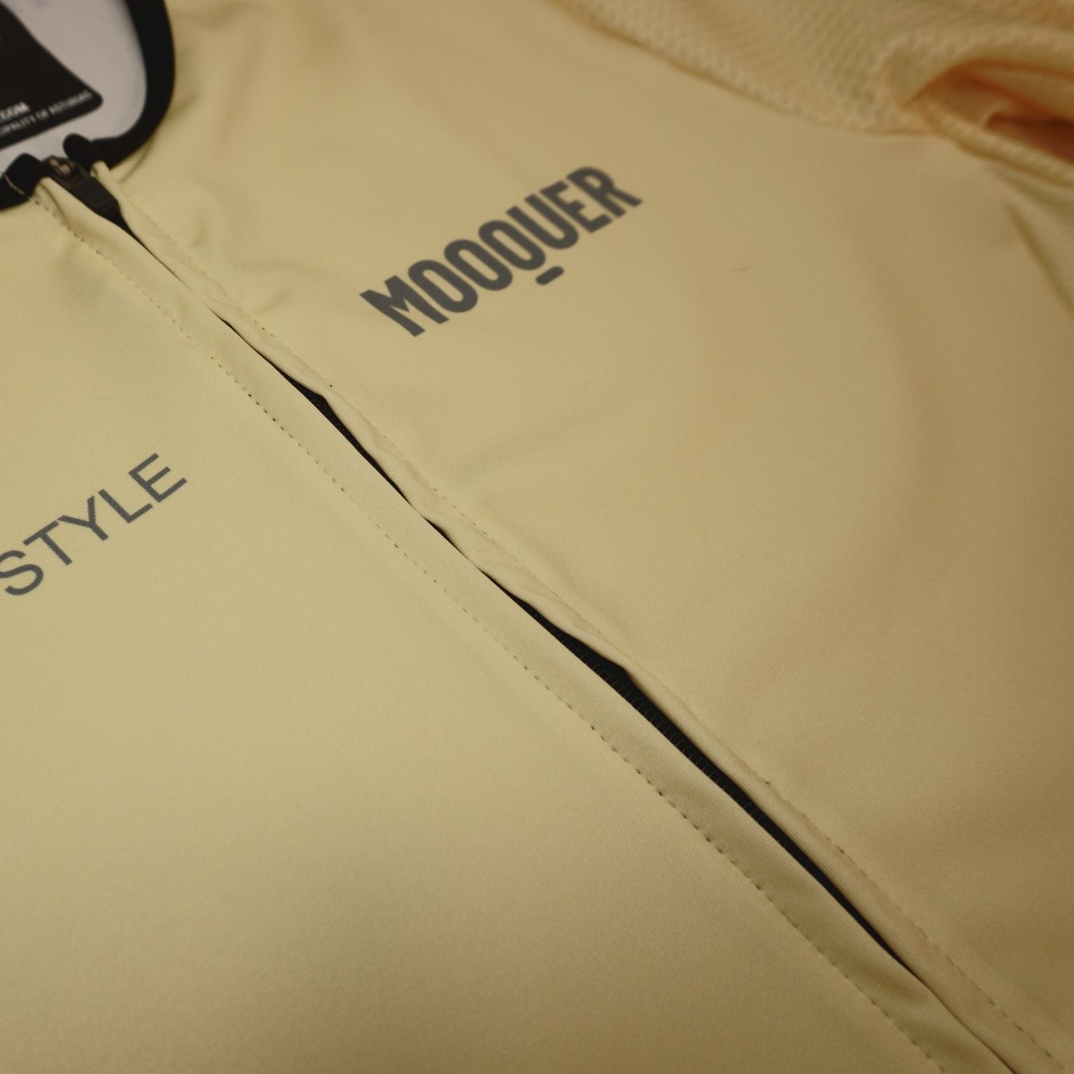 Acercamiento a la cremallera YKK del maillot crema Mooquer con costuras reforzadas y forro interior