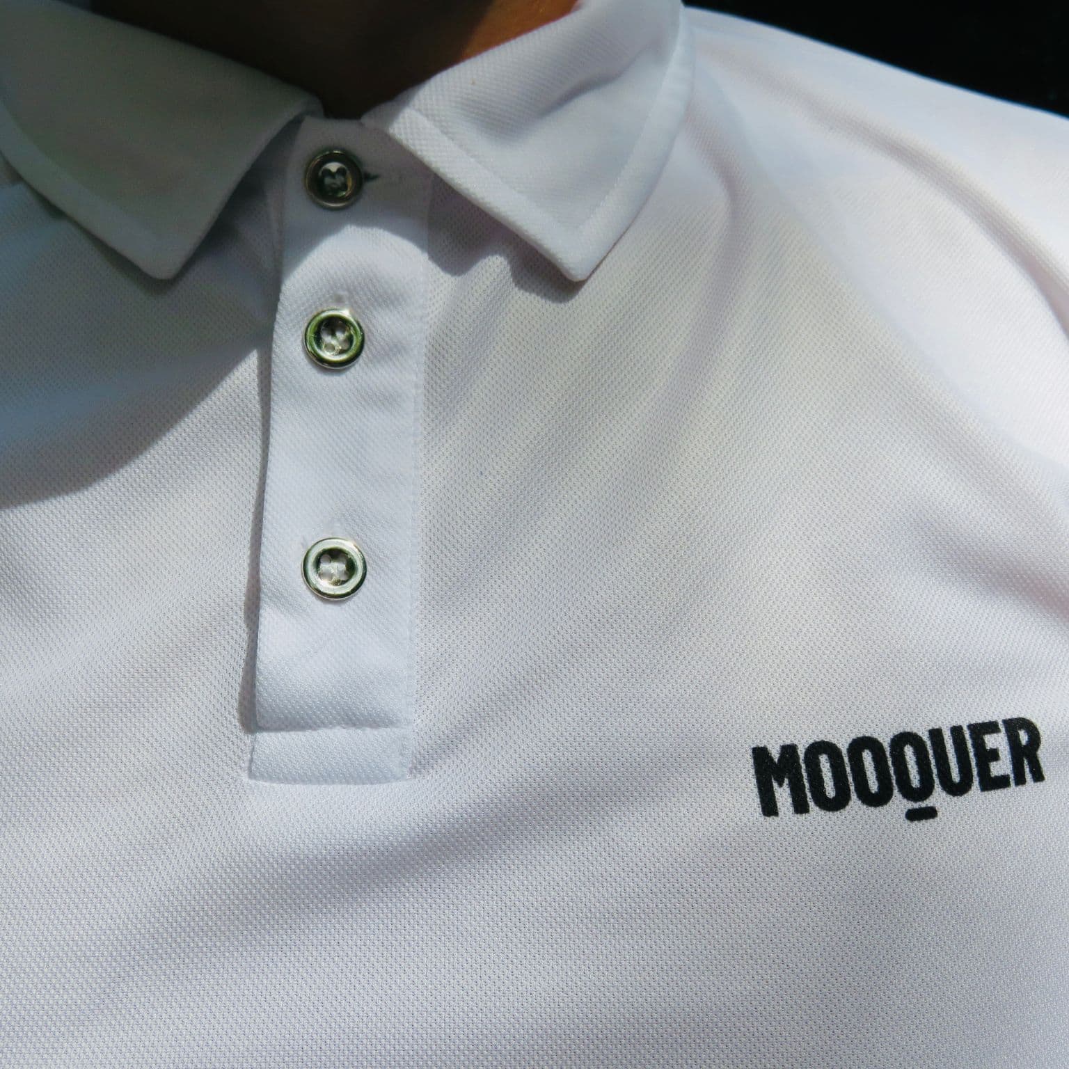Detalle del cuello y la tapeta del Polo White Crew, acabado técnico y minimal