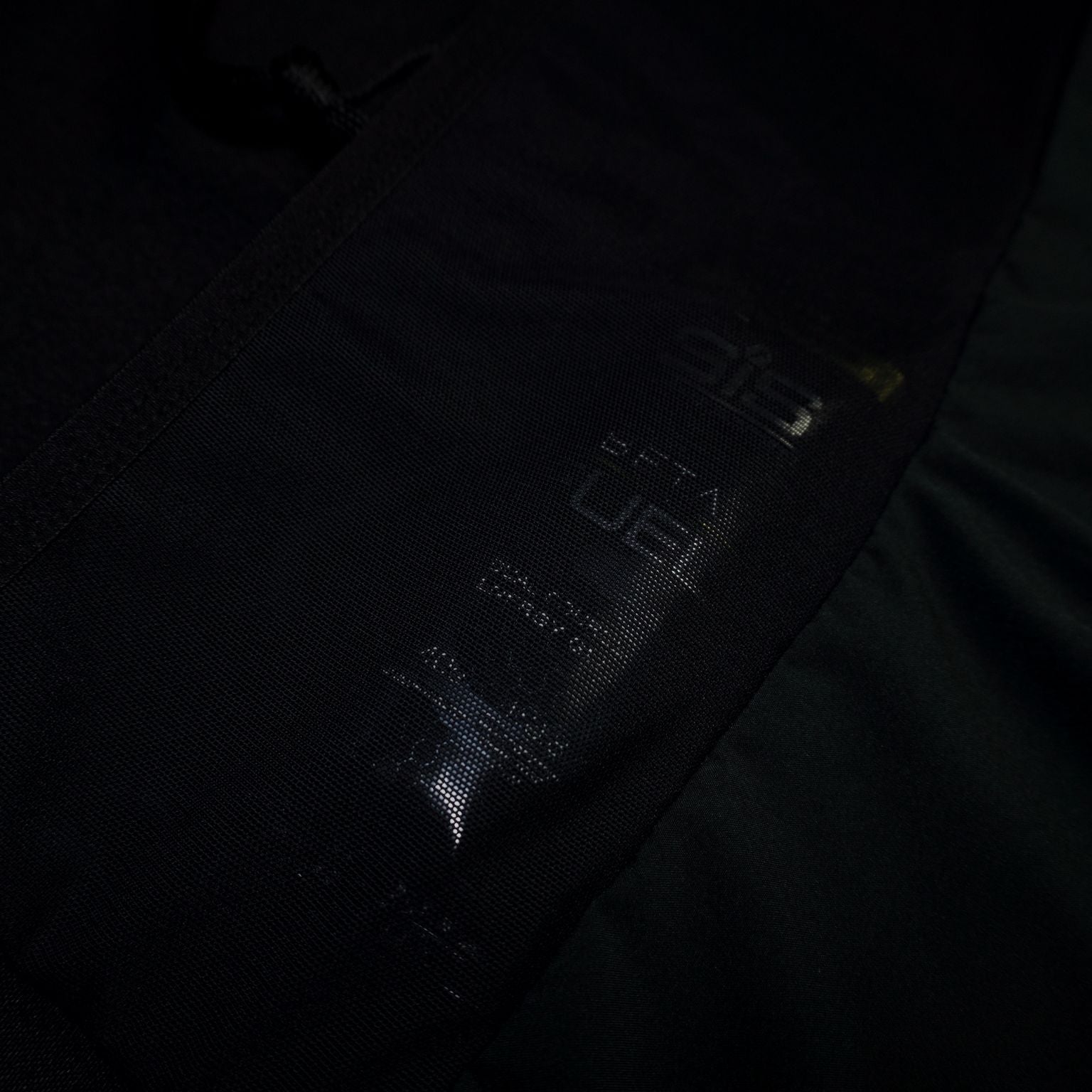 Detalle frontal del pantalón running negro Mooquer con cordón trenzado y costura reforzada en cinturilla