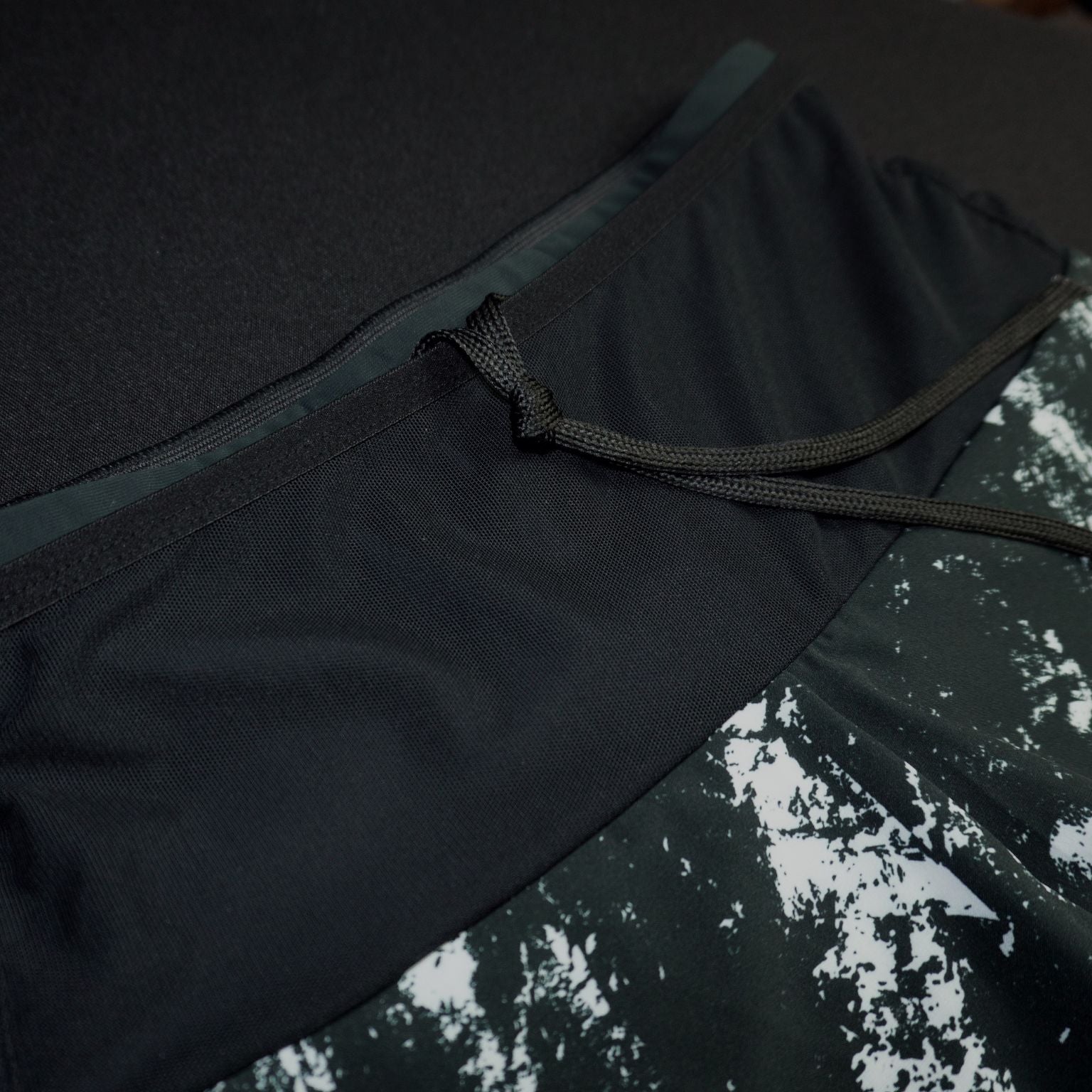 Pantalón corto running negro Mooquer con estampado pictórico blanco efecto pintura y cintura ajustable