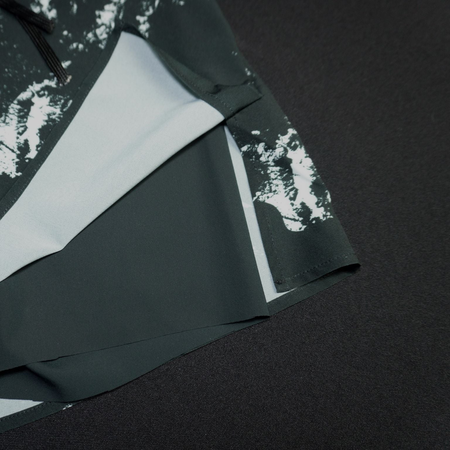 Detalle frontal del pantalón running negro con cordón ajustador y forro interior de malla transpirable